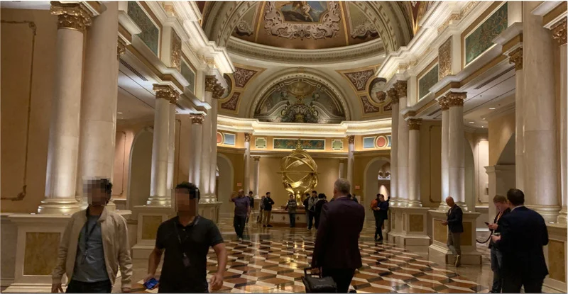 Main Reception Isle of the Venetian Hotel in Las Vegas, USA with ornate columns and golden decor. Vistors are walking through it.