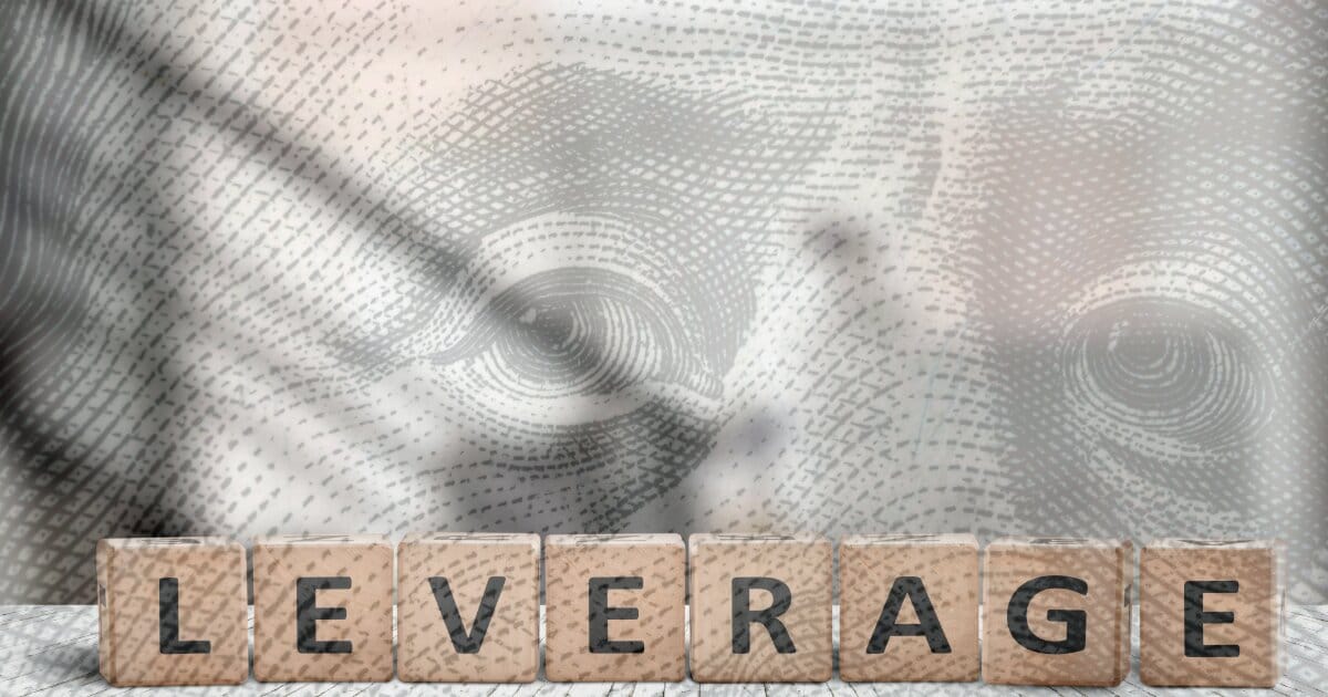 Blended image of a wooden block set saying, LEVERAGE. This forefront is backed with an opague image of Benjamin Franklin's from the US Dollar.