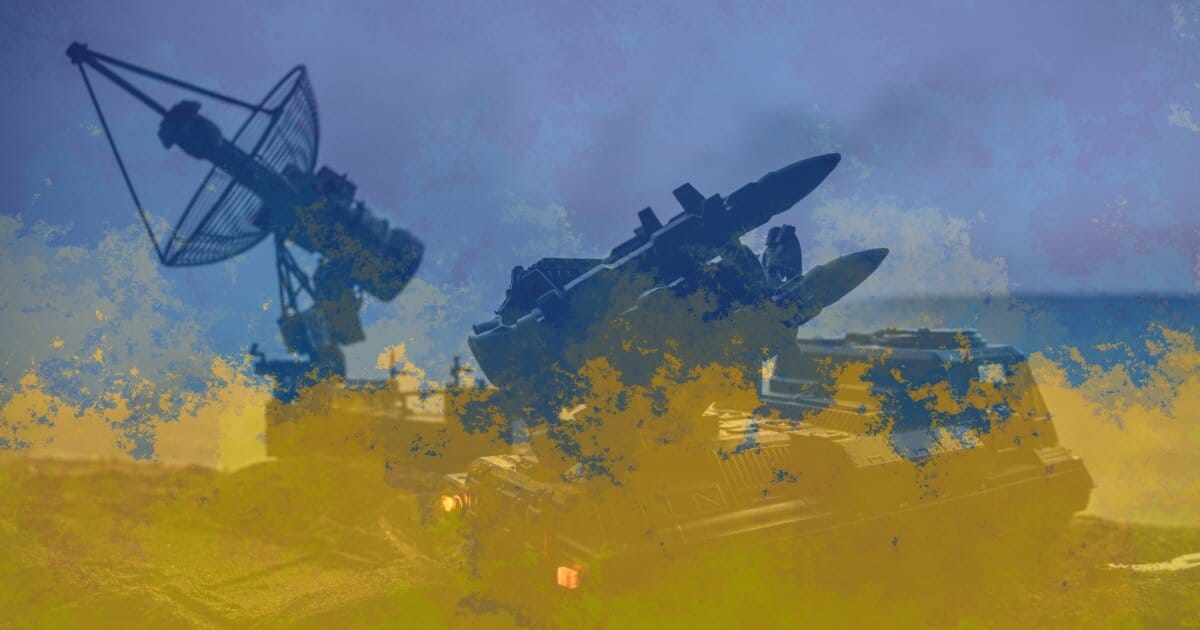 National Ukrainian colors blended into an image of a mobile tactical rocket launch system parked in an open space with a clear sky overhead.